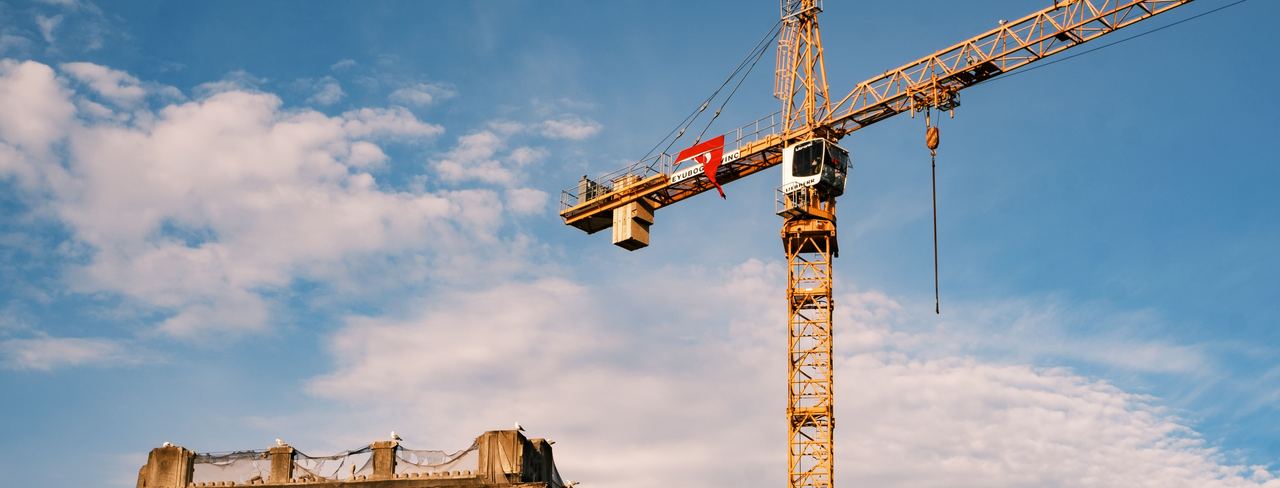 A tower crane above a building against a blue sky